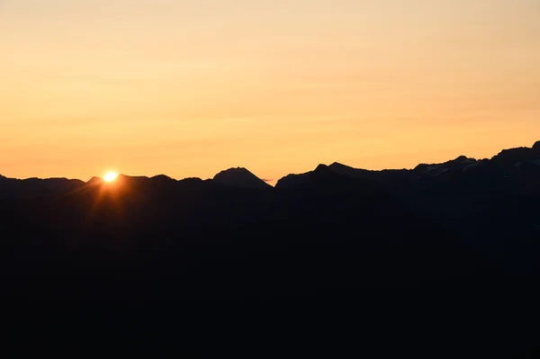 Sun Rising over British Columbia Mountain Horizon