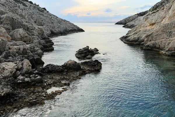 Minimalist landscape with black and gray rocks and cliff over blue sea