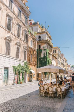 People sit at an Italian cafe eating in Rome, Italy