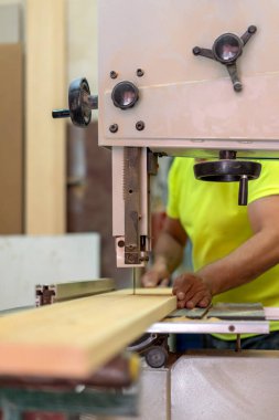 master carpenter cutting wood in his workshop with his saw machine