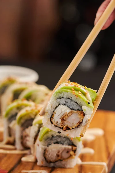 Mano Del Hombre Sosteniendo Palillos Con Sushi — Foto de Stock