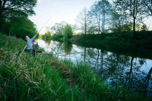 息子と父は川岸で釣りをしている — ストック写真