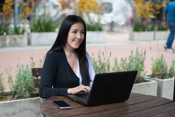 woman working on laptop in a cafe. Business woman working outdoor.