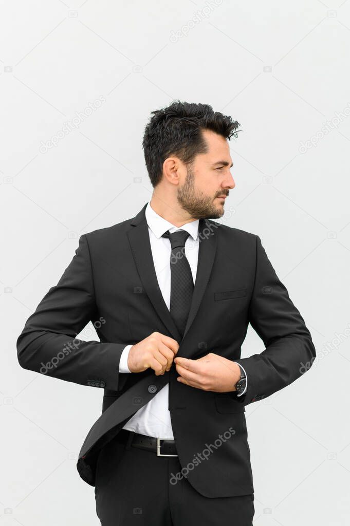 Profile of a handsome young man in black suit and tie