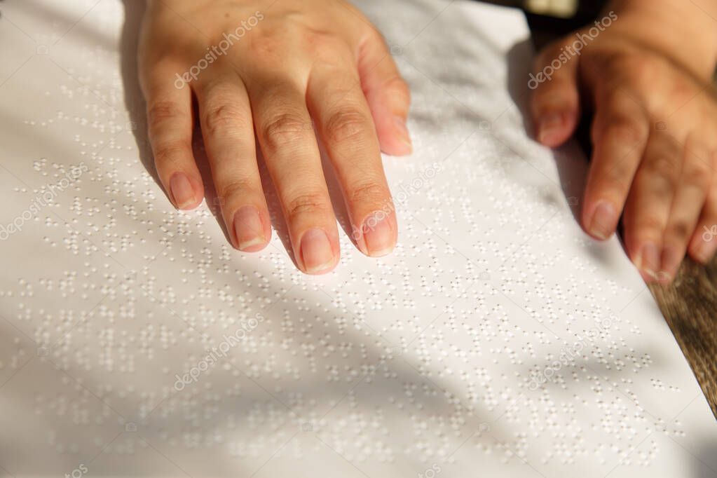 Woman put her hands on a braille page