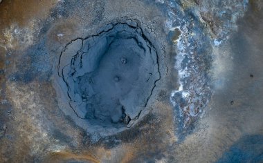 Pool with bubbling mud in volcanic terrain