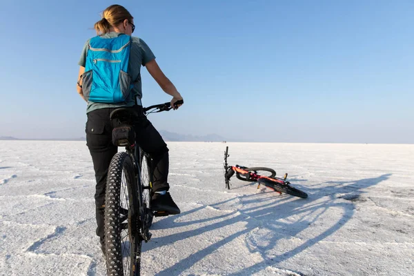 ユタ州のBonneville Salt Flatsで自転車に乗っている若い女性 — ストック写真