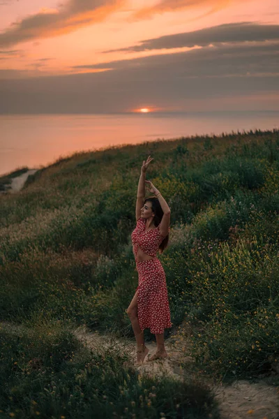 happy girl jumping at sunset in summer, is in motion