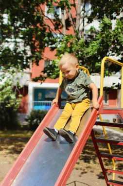 Çocuk bahçede kayıyor.