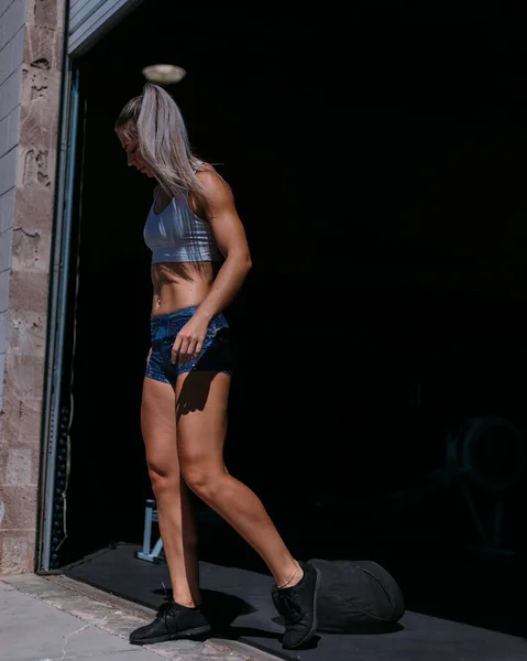 Athletic Woman Sports Bra Walking Out Gym Sunlight — стоковое фото