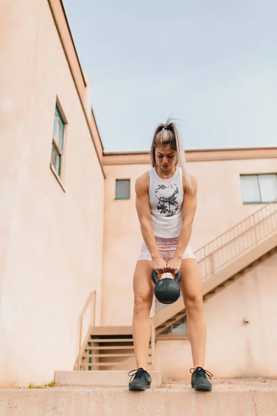 Young Female Doing Kettlebell Deadlifts Old Building — стоковое фото