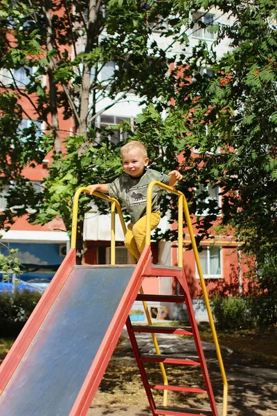 Çocuk bahçede kayıyor.