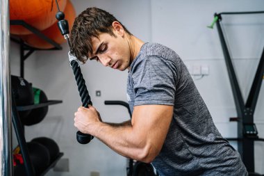 Strong sportsman looking at bicep during workout