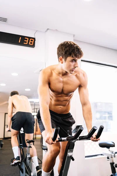 Young Sportsman Exercising Bike Mirror — Stockfoto