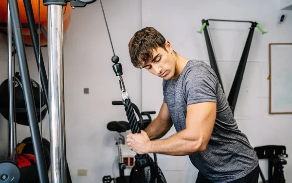 Strong Sportsman Exercising Cable Machine — Stockfoto