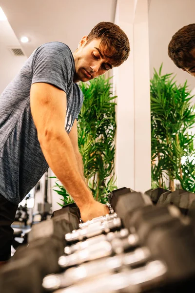 Male Athlete Taking Dumbbells Looking Bicep — Stockfoto