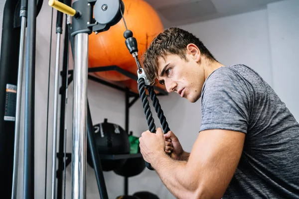Determined Male Athlete Exercising Cable Machine — Stockfoto