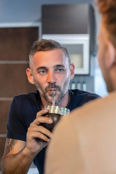 Młody Mężczyzna Rozmawia Podczas Gdy Jego Mąż Pije Infuzję — Zdjęcie stockowe