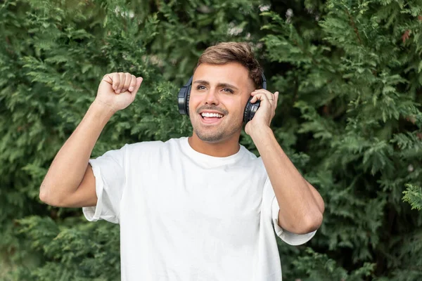 Bonito Jovem Vestindo Fones Ouvido Ouvindo Música Enquanto — Fotografia de Stock