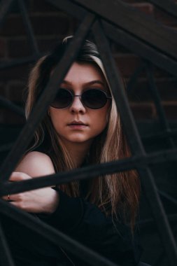 Siyah metal parmaklıklar, arka planda genç bir kız.