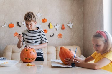 Çocuklar Cadılar Bayramı 'na hazırlanıyor, balkabaklarını boyayıp kesiyorlar..