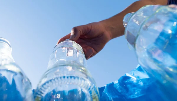 ガラス瓶を青いリサイクルビンに入れる男 — ストック写真