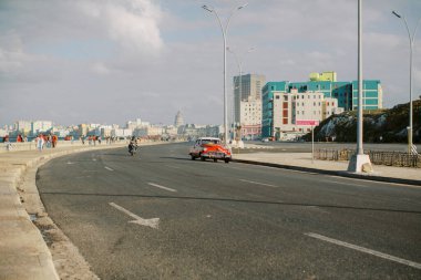 Eski Havana, Küba 'da güneşli bir şehirde kırmızı klasik bir araba sürüyordu.