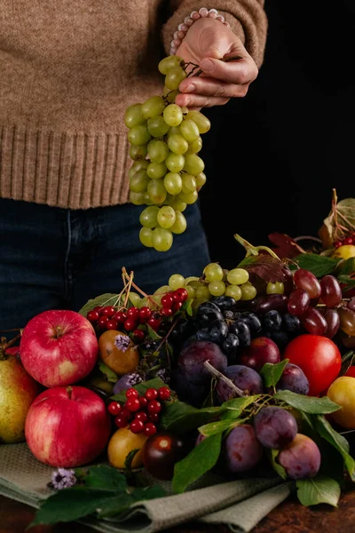 Egy Lány Zöld Szőlőt Tart Őszi Gyümölcsök Hátteréhez — Stock Fotó