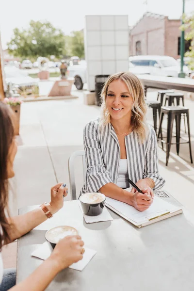 Two women having a work meeting outside coffee shop