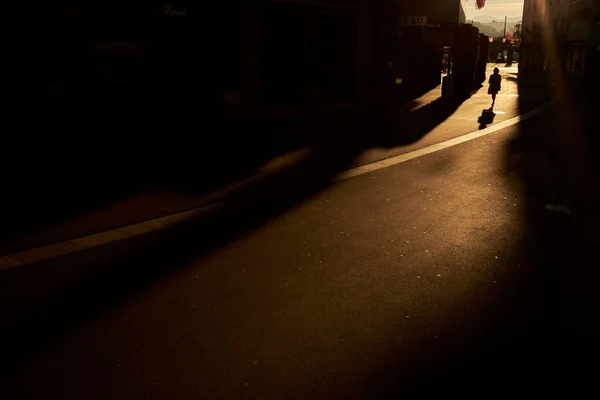 匿名の女性は明るい日差しの中で通りを歩く — ストック写真