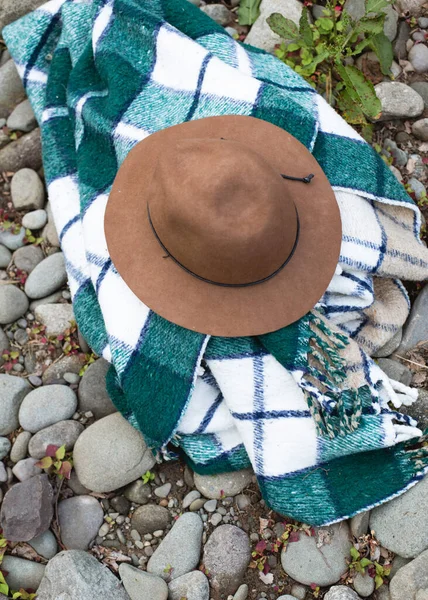 緑のスカーフと大きな茶色の帽子が地面に座っている — ストック写真