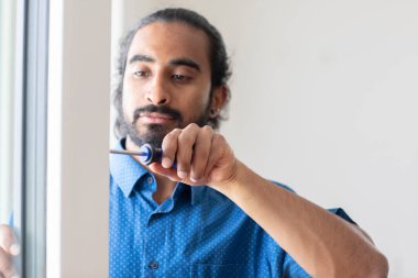 Bir odada tornavidayla kapıyı tamir eden bir adam.