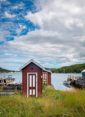 Okyanus kıyısındaki Newfoundland kırsalındaki kırmızı balıkçı kulübeleri..