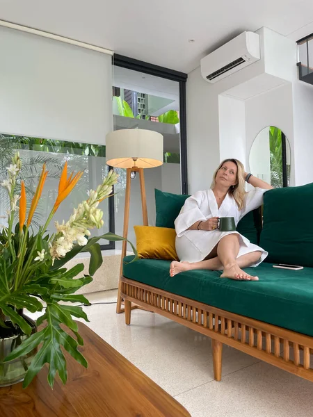 Frau Weißen Mantel Sitzt Auf Grünem Sofa — Stockfoto