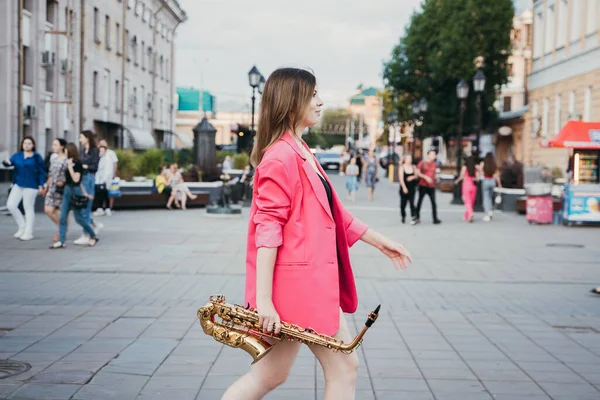 Uma Menina Casaco Rosa Com Saxofone Caminha Longo Rua Cidade — Fotografia de Stock