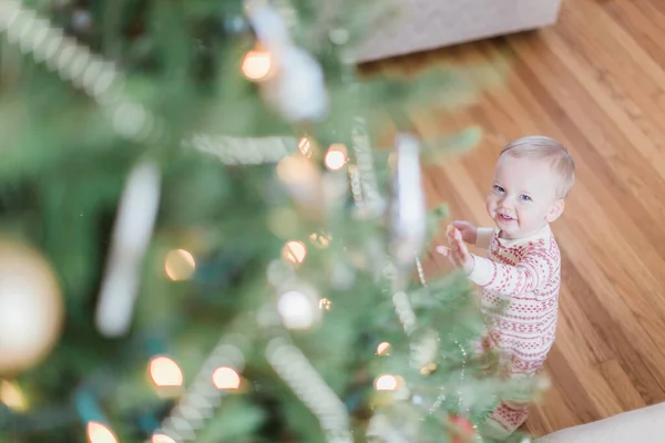 小男孩坐在圣诞树前 面带微笑 — 图库照片