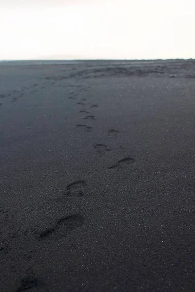 Fußabdrücke Schwarzen Sandstrand — Stockfoto