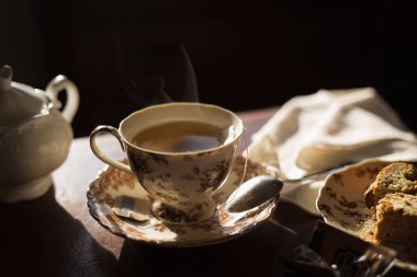 Sabah ışığında buharlı bir fincan çay.