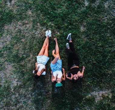 bird's eye view of three women lying on the grass