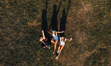 bird's eye view of three women lying on the grass
