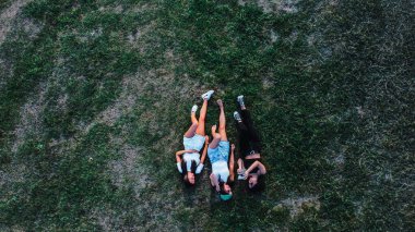 bird's eye view of three women lying on the grass