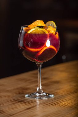 Ahşap bir masada, cam içinde sangria içeceği..