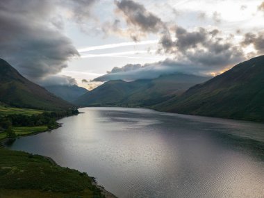 Güneş, ıssız suların kıyısındaki ağaçları aydınlatıyor.