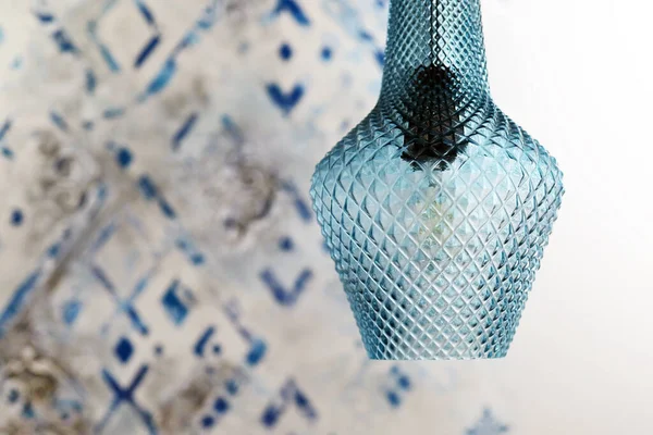Blue lamp on the background of an Arabic geometric pattern on the wall