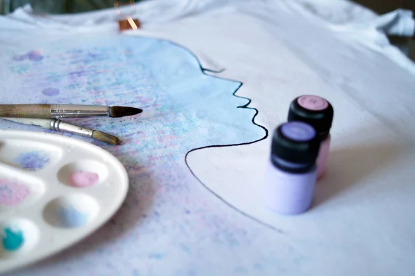 The process of painting with paints on a T-shirt
