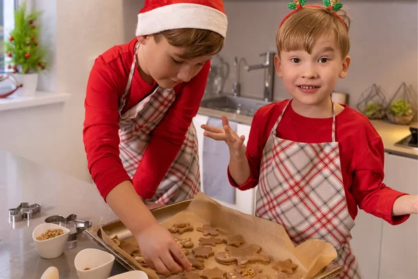 2个男孩在厨房做饭和吃圣诞饼干 — 图库照片