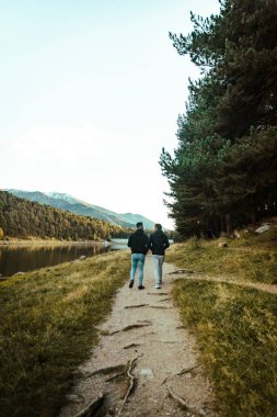 Dostlar göl kenarında sessizce yürürken
