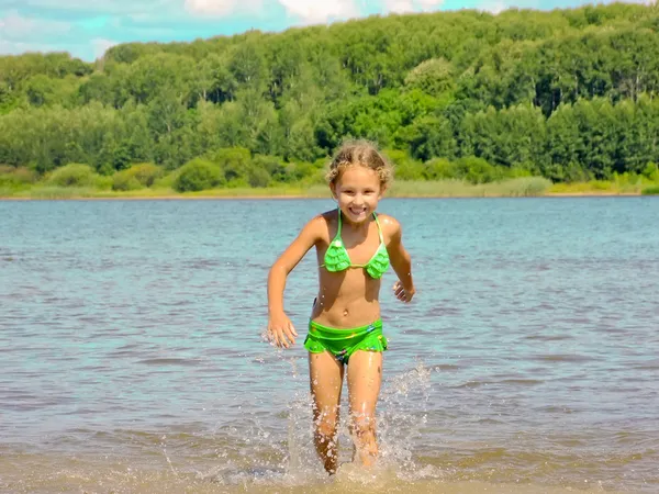 Niño feliz corre sobre el agua Fotos De Stock Sin Royalties Gratis