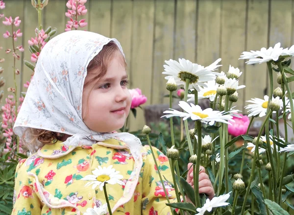 Child in the garden with flowers — Stock Photo, Image