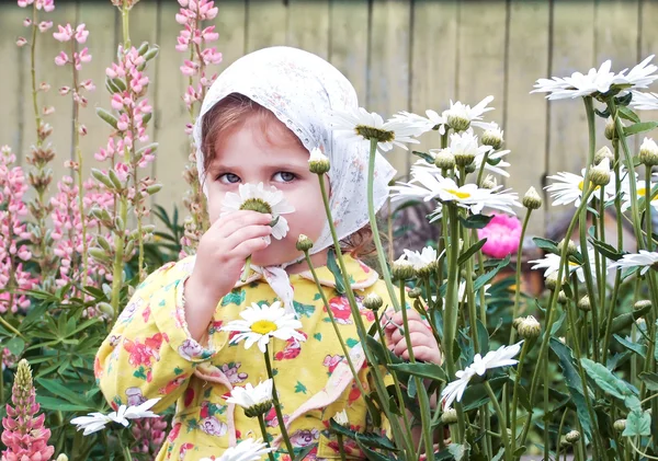 Child in the garden with flowers — Stock Photo, Image